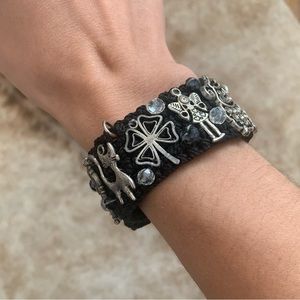 Black wooven bracelet with assorted silver tone charms